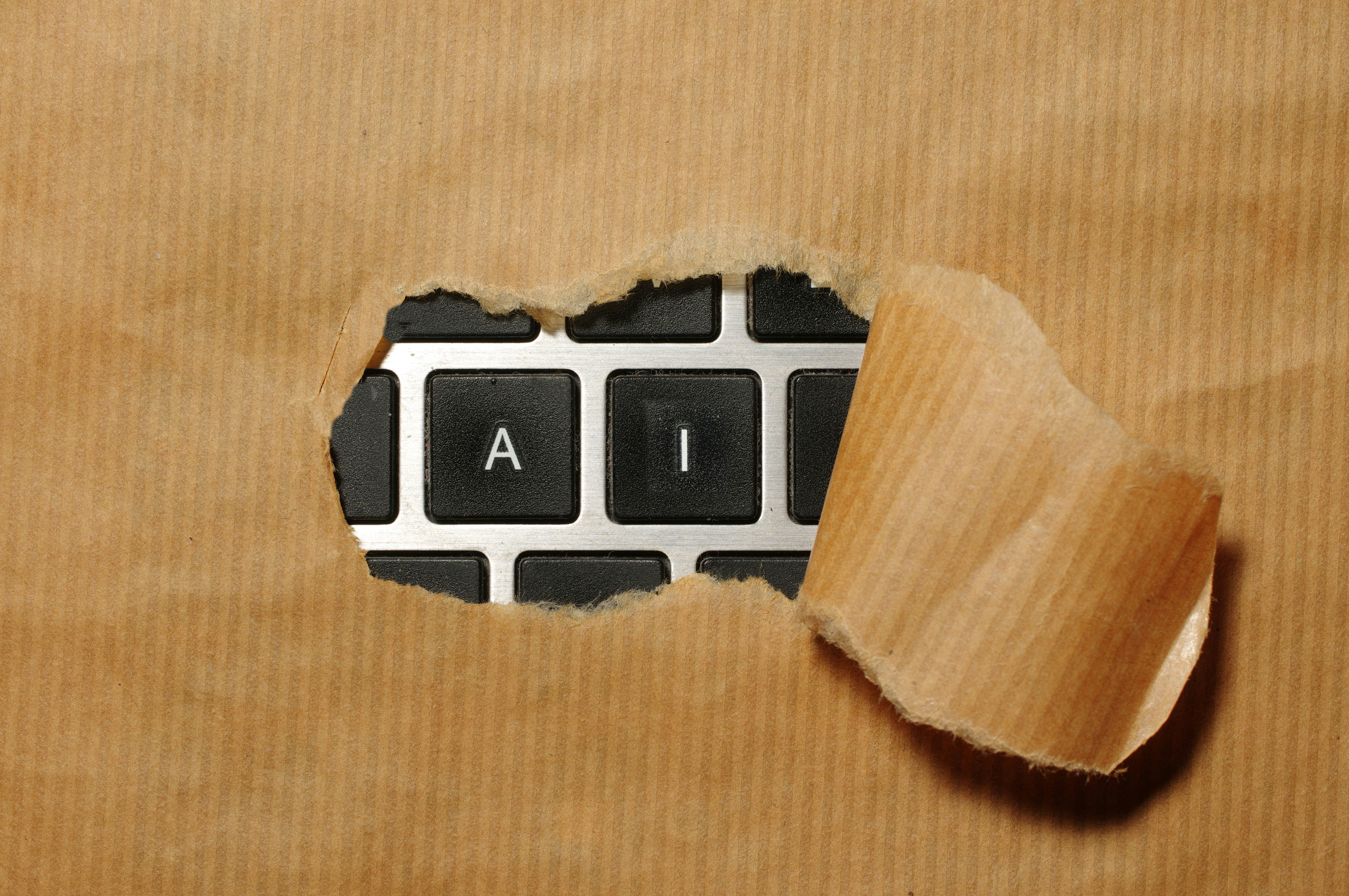 AI jobs concept with torn paper revealing AI keys on a keyboard